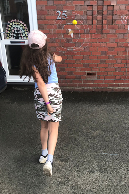 Girl throwing an object at a wall target